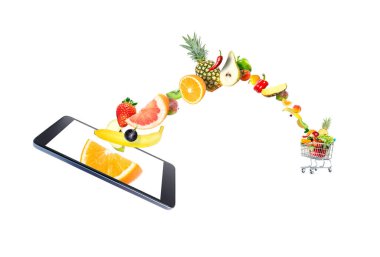 Taze sebze ve meyve modern bir gadget, cep telefonu, beyaz bir arka planda izole kalabalık bir alışveriş sepeti içine uçan. Yaratıcı fikir online alışveriş.