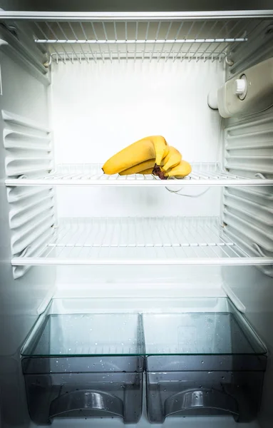 Plátanos frescos brillantes en el estante del refrigerador vacío abierto. concepto de dieta de pérdida de peso . — Foto de Stock
