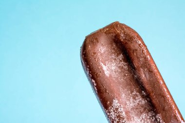 Bir yaz mavi gökyüzü arka plan üzerinde yoğuşma ve buzlanma don ile çikolata sır yakın çekim dondurma lolly.