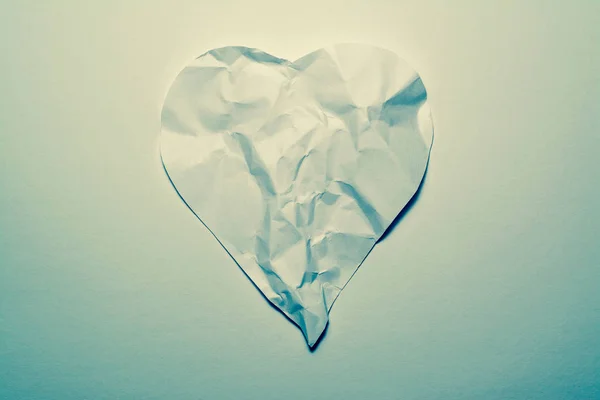 Herzsymbol aus altem, zerknittertem Papier auf weißem Vintage-Hintergrund. Symbol eines gebrochenen Herzens, unglücklicher Liebe. — Stockfoto