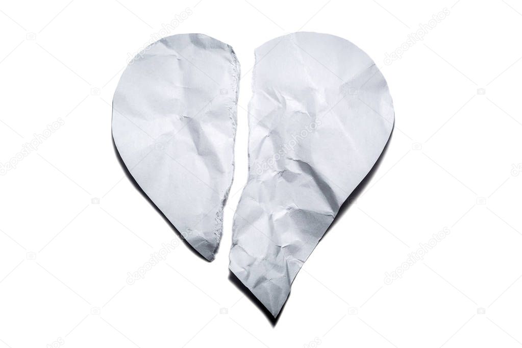 Heart symbol from old, crumpled paper, torn in half isolated on a white background. Symbol of a broken heart, unhappy love.