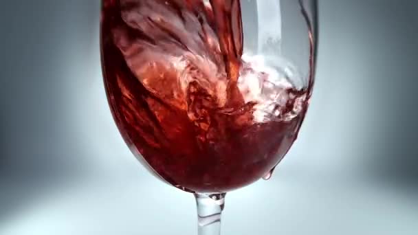 ガラスに注ぐ赤ワインの創造的なマクロスローモーションビデオ 赤ワインを注ぐガラスのクローズアップ — ストック動画
