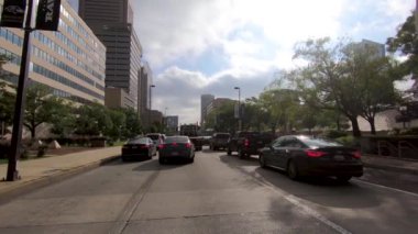 26 Eylül 2018. Baltimore, Amerika Birleşik Devletleri. Baltimore'daki Sokak Trafiği. Arabalar kalabalık sokaklardan geçiyor. Trafik geçiyor. Yavaş Çekim. Şehir silueti, gökdelenler ve Baltimore binaları Pov görünümü. Şehir trafiği.