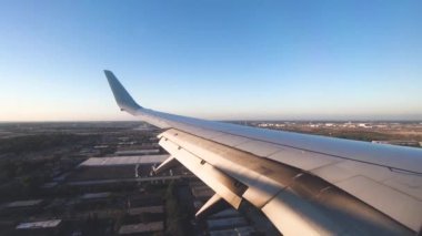 Uçak inişi. Uçak penceresi görünümü. Hava yolculuğu. Uçak pencere koltuğundan görünüm. Uçan bir uçağın kanadı. Yavaş Çekim. 