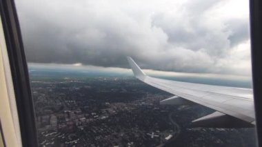 Uçak pencere görünümü. Hava seyahat. Airplane pencere koltuğundan görüntüleyin. Renkli gökyüzü ile bulutlar üzerinde uçan bir uçağın kanat. Uçak irtifa kazanır. Uçuş türbülans. Yavaş hareket.