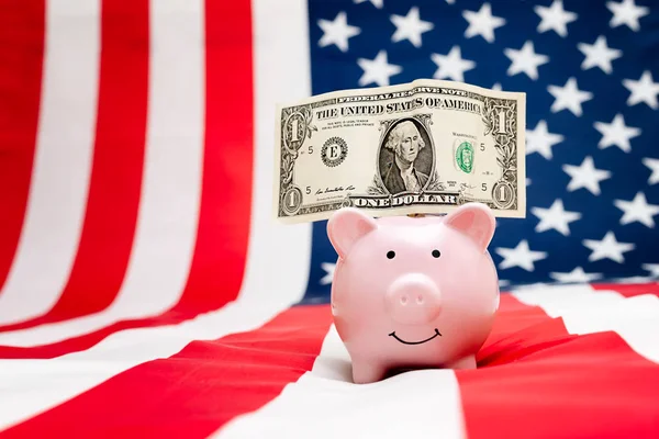 Κουμπαράς με ένα δολάριο στο φόντο της αμερικανικής σημαίας — Φωτογραφία Αρχείου