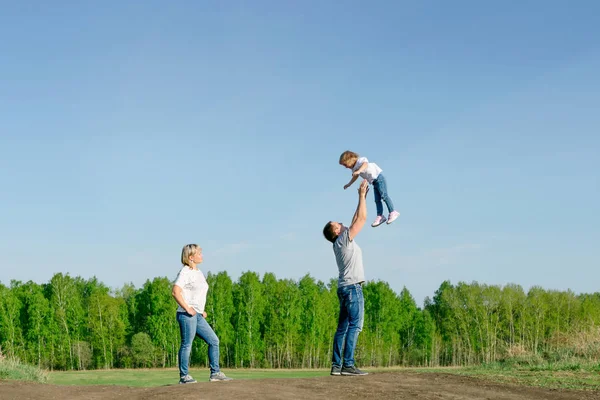 Familia de tres jugando en la naturaleza — Foto de Stock