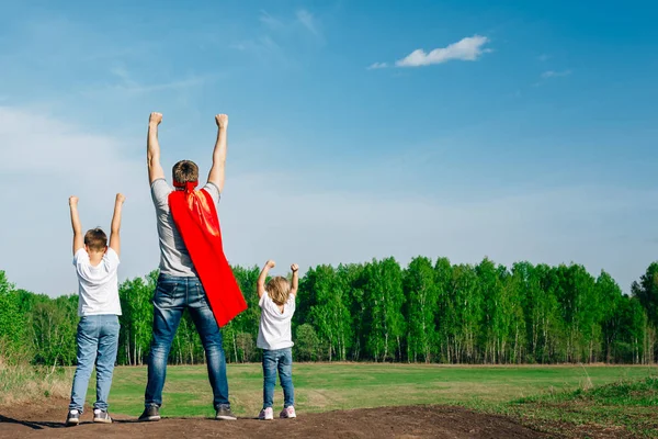 super-dad with son and daughter in the summer in nature