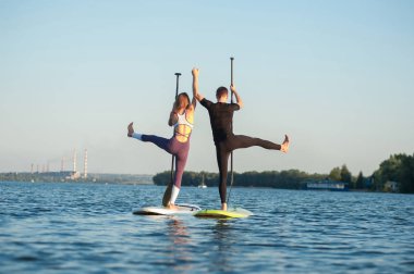 raket Pano yoga parlak arka planda, yoga eğitim kumsalda güzel çift tarafından gerçekleştirilen ayağa