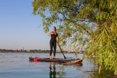 kürek kurulu yoga yoga su eğitim parlak şehir arka plan güzel kız tarafından gerçekleştirilen ayağa