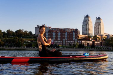 kürek kurulu yoga yoga su eğitim parlak şehir arka plan güzel kız tarafından gerçekleştirilen ayağa