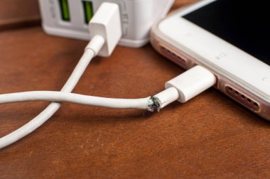Masada smartphone ile bağlayan zarar görmüş şarj kablosu görüntüsünü kapatmak