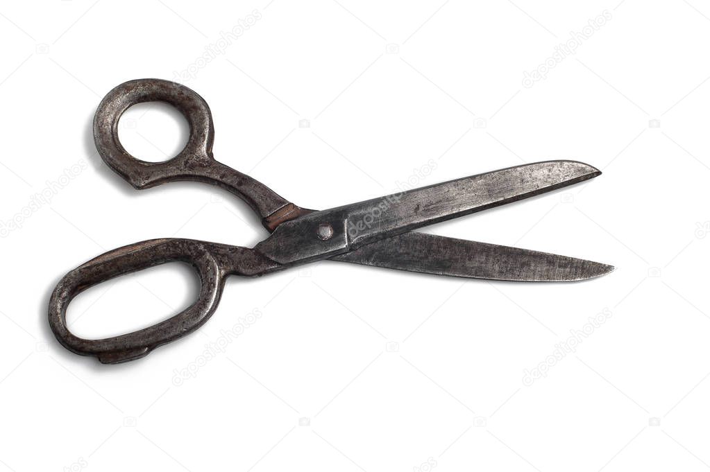 Old large scissors open on a white background