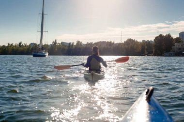 Toplantı günbatımı kayaklar üzerinde. Arka planda günbatımı ile birlikte gölde güzel genç çift Kayak görünümü