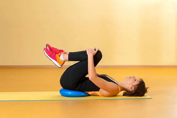 Mujer deportiva haciendo ejercicios terapéuticos en el gimnasio interior — Foto de Stock