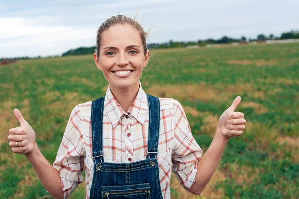 caring for the environment. Country woman standing on grassland and showing thumb up signifying her success