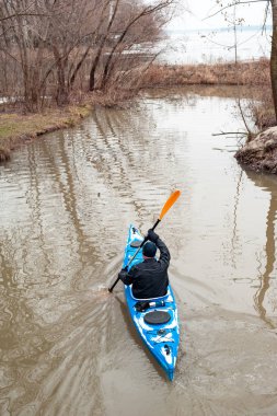 Arkadan görünüşü üzerinde mavi spor kano rafting ve durgun dışarı almaya çalışırken atlet