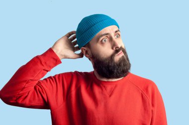 Genç ciddi düşünceli iş adamı. Mavi arka plan üzerinde izole kavramı şüpheliyim. Şaşırmış gibi genç deli adam stres hissediyor