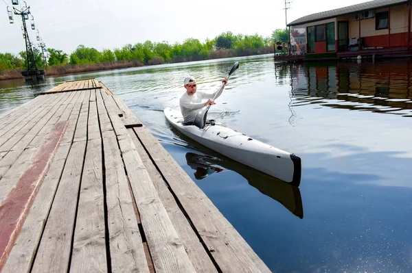 Remero macho navegando en canoa por el lago usando remo en el día de verano —  Fotos de Stock