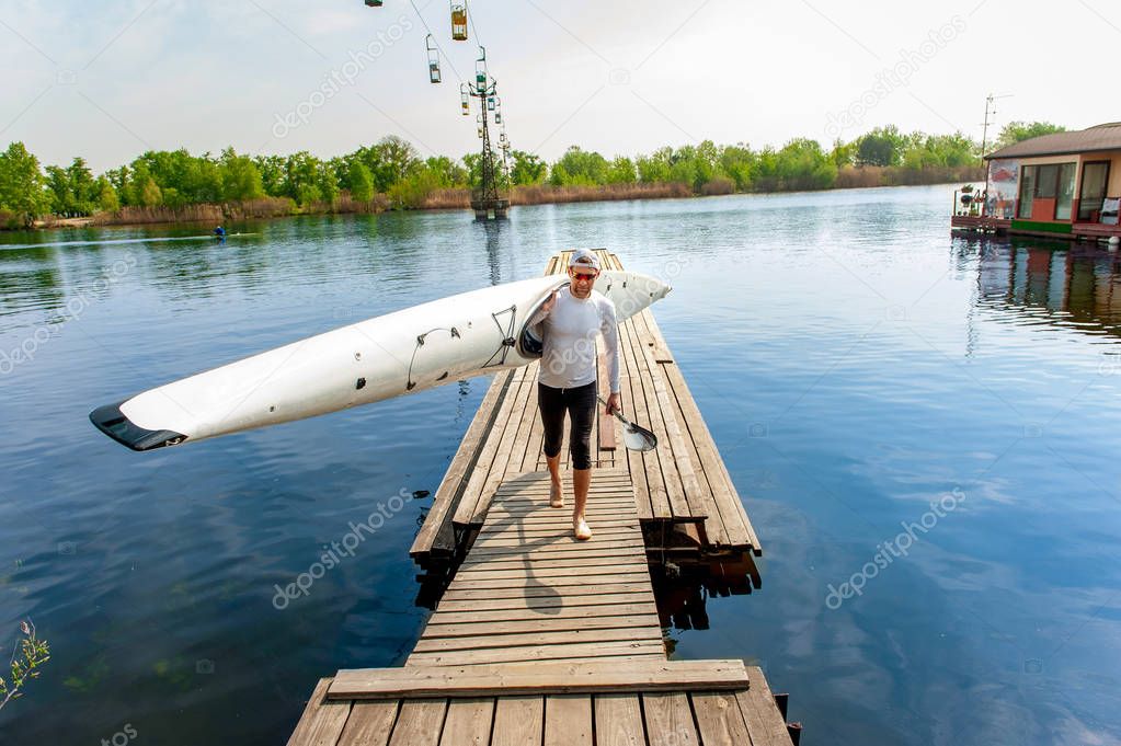 Athletic kayaker with his boat and paddle after rafting