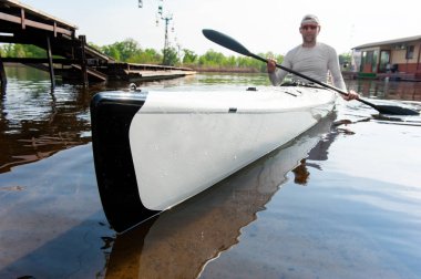 İskele yakınında kürek ve kano tekne ile Adam