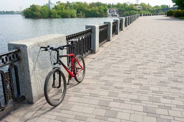 Связанная дорожка вдоль реки и велосипед, установленный рядом с забором — стоковое фото