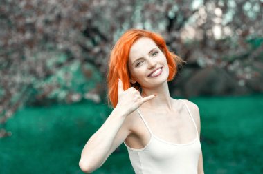 Güzel kız parmağıyla bir telefon görüşmesi taklit