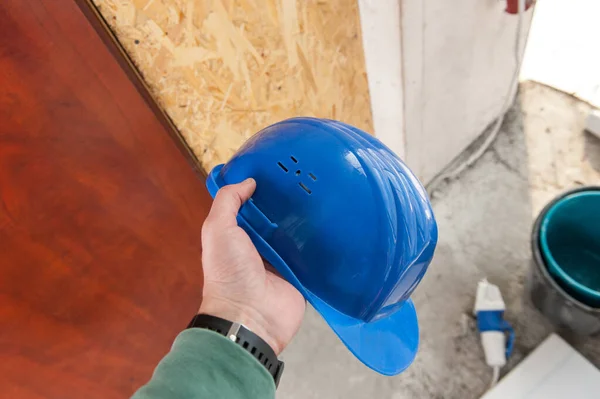 建筑商手里拿着蓝色的建筑头盔 安全概念 免版税图库照片