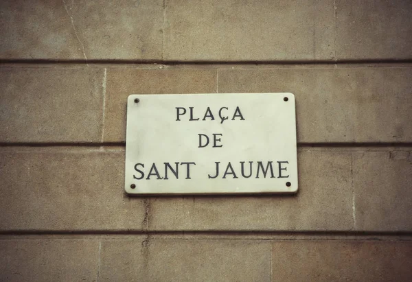 Sign on the wall of a building in Barcelona with the name Plaza de Sant Jaume. Famous square on which the building of the government of Catalunya and Casa de la Ciudad de Barcelona, city hall