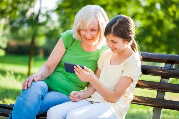 Grandmother Granddaughter Sitting Park Using Mobile Phone — Stock Photo, Image