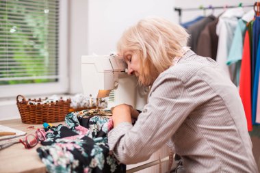 Yetişkin kadın stüdyosunda dikiş var. Çok yoruldu.