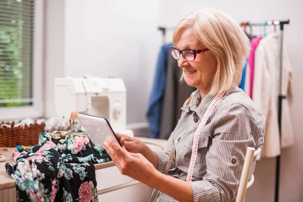 Yetişkin kadın dikiş onun stüdyosunda olduğunu..