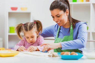 Mutlu anne ve kızı çerezleri onların mutfakta yapıyoruz. 