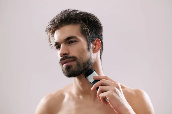 Joven Afeita Barba Con Una Navaja Eléctrica — Foto de Stock