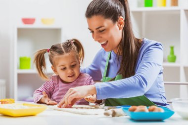 Mutlu anne ve kızı çerezleri onların mutfakta yapıyoruz. 