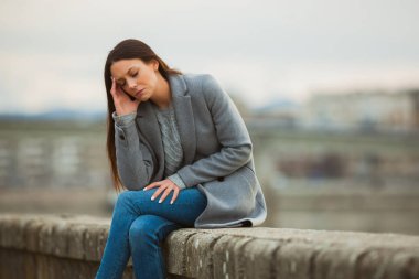 Yorgun kadın işten sonra baş ağrısı geçiriyor. 