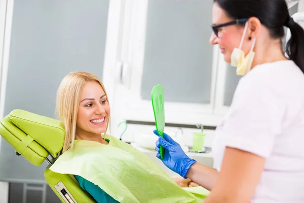 Junge Frau Blickt Nach Erfolgreicher Zahnbehandlung Auf Ihre Zähne lizenzfreie Stockfotos