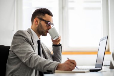 Genç işadamı ofisinde çalışıyor. 