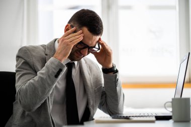 Genç işadamı baş ağrısı geçiriyor.