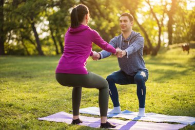 Fizyoterapist genç hastaya siyatik kurtarma için egzersizler gösteriyor.