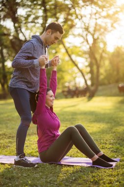 Fizyoterapist genç hastaya siyatik kurtarma için egzersizler gösteriyor.