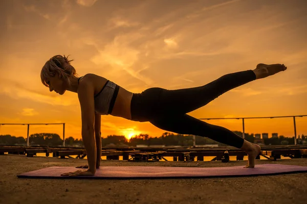Žena Která Cviče Zapadajícím Slunci Lamela Zdvihněte Nohou — Stock fotografie