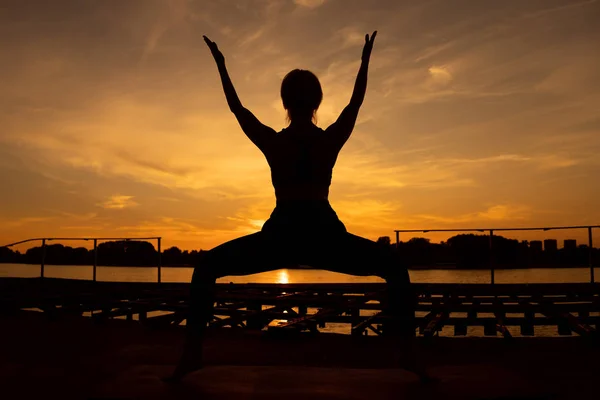 女人在日落时练习瑜伽 乌特卡塔萨纳 主席姿势 — 图库照片