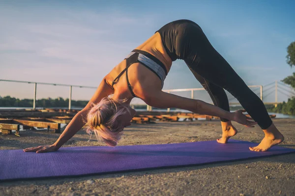 Güneşli bir günde pilates uygulayan kadın. Yan yüksek pike viraj egzersiz. 