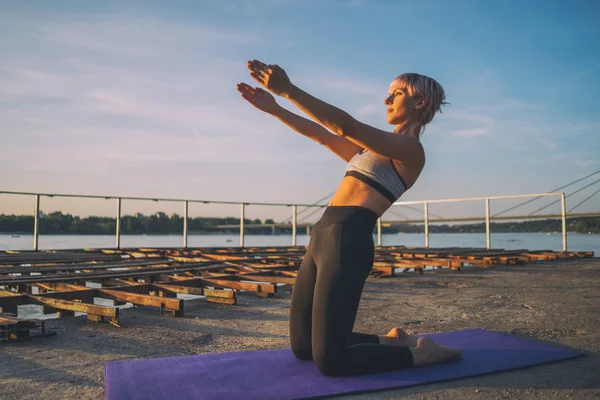 Güneşli günde pilates egzersizi yaptığı kadın.