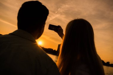 Mutlu çift şehirde Günbatımı Fotoğraf çekirken. 