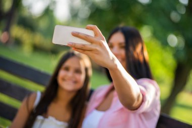 Mutlu bir aile birlikte parkta güzel vakit geçiriyoruz. Onlar selfie alıyor.