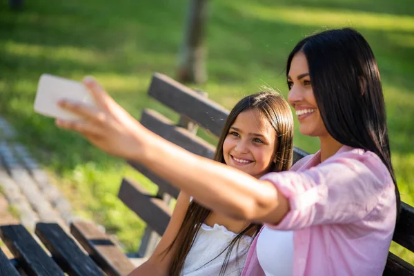 Mutlu bir aile birlikte parkta güzel vakit geçiriyoruz. Onlar selfie alıyor.