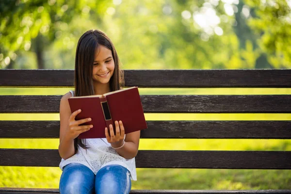 Счастливая Маленькая Девочка Читает Книгу Парке — стоковое фото