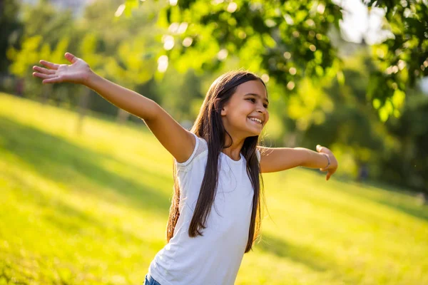 幸せな小さな女の子は公園で自然を楽しんでいます — ストック写真